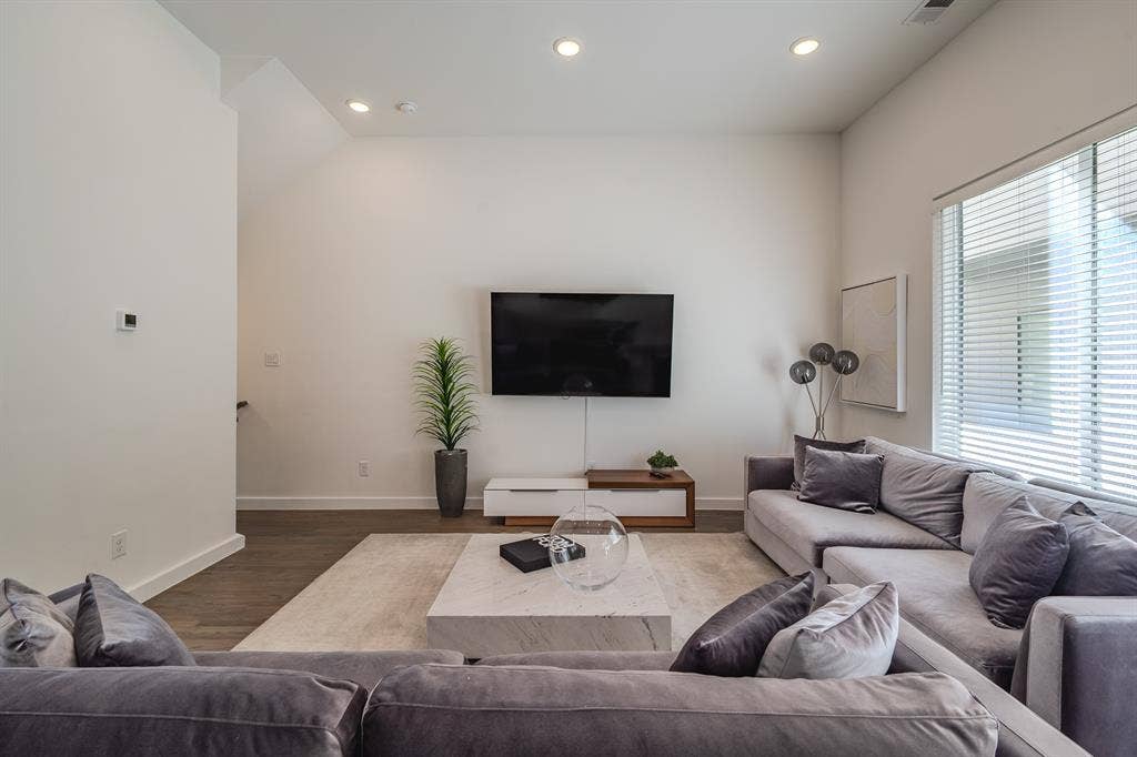 1502 Bennett Avenue, #106, Dallas, TX 75206 Living area featuring vaulted ceilings, recessed lighting, wood-finish flooring, and large windows with horizontal blinds