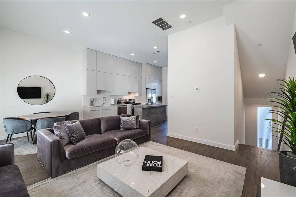 1502 Bennett Avenue, #106, Dallas, TX 75206 Kitchen featuring flat-panel cabinetry, a stone-finish kitchen island, recessed lighting, and wood-finish flooring