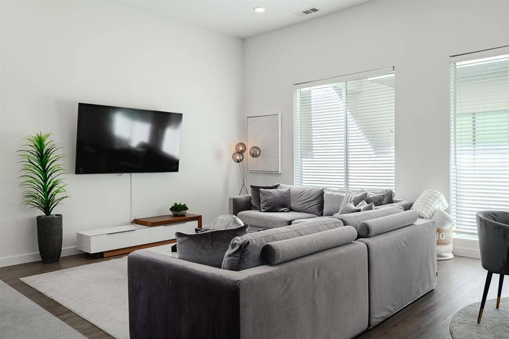 1502 Bennett Avenue, #106, Dallas, TX 75206 High-ceiling living area featuring recessed lighting, large windows with horizontal blinds, and dark wood-finish flooring