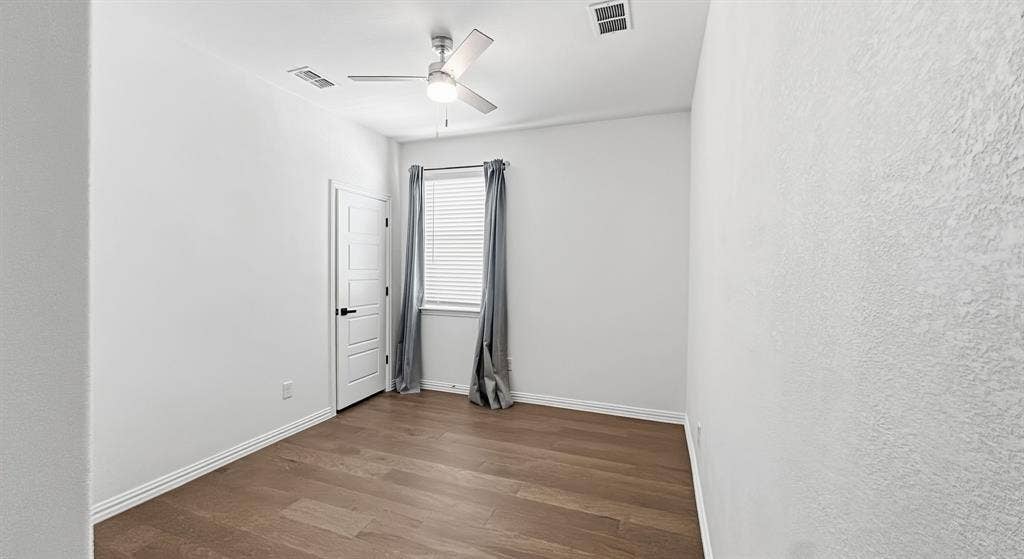 3129 Grayslick Avenue, Celina, TX 75009 Interior room featuring wood-finish flooring, a neutral color palette, a ceiling fan with integrated lighting, and a multi-panel door with matte black hardware