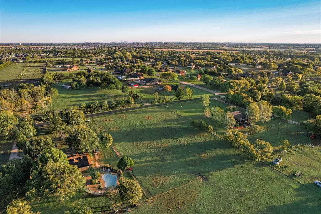 0 Johnson Lane, Ovilla, TX 75154 Aerial perspective featuring expansive acreage, mature tree clusters, and a ground-level swimming pool with stone-finish decking