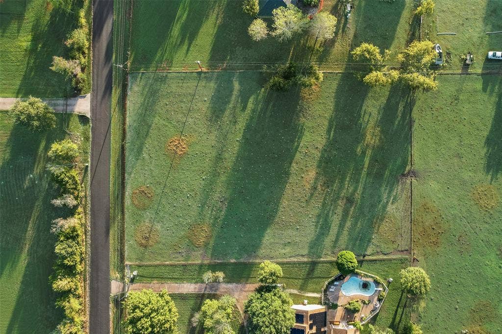 0 Johnson Lane, Ovilla, TX 75154 Expansive rectangular lot featuring established perimeter fencing, scattered mature trees, and direct paved road frontage