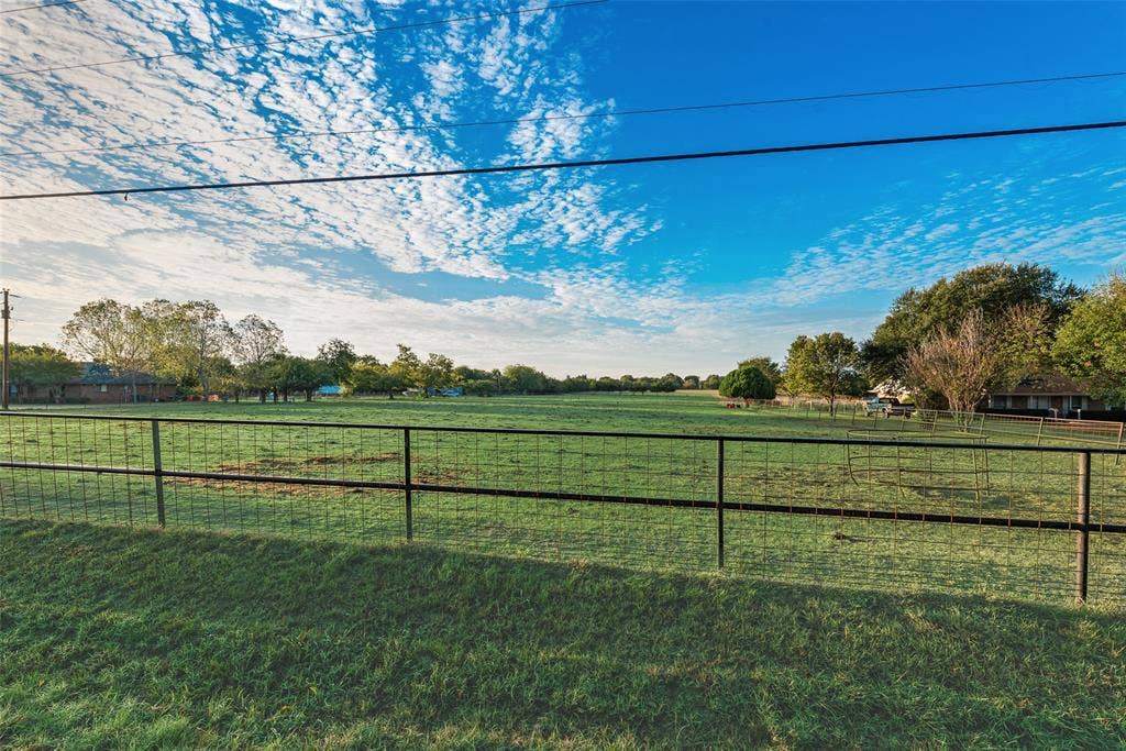 0 Johnson Lane, Ovilla, TX 75154 Expansive open acreage featuring manicured grass, mature trees, and wire-mesh perimeter fencing
