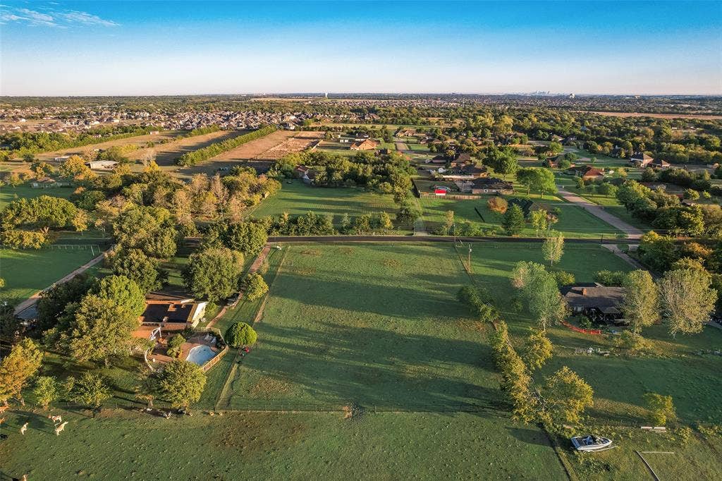 0 Johnson Lane, Ovilla, TX 75154 Aerial perspective of expansive acreage featuring vast open green space, mature tree lines, and a residential structure with an integrated swimming pool