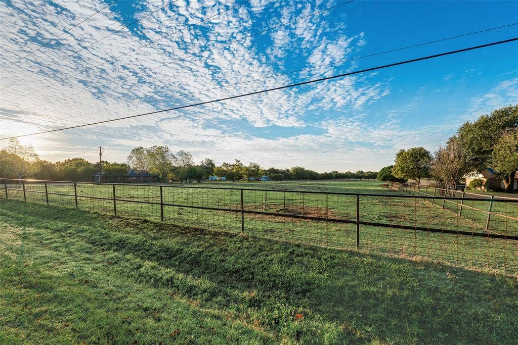 0 Johnson Lane, Ovilla, TX 75154 Expansive open acreage featuring manicured grass pasture, perimeter pipe fencing, and mature trees