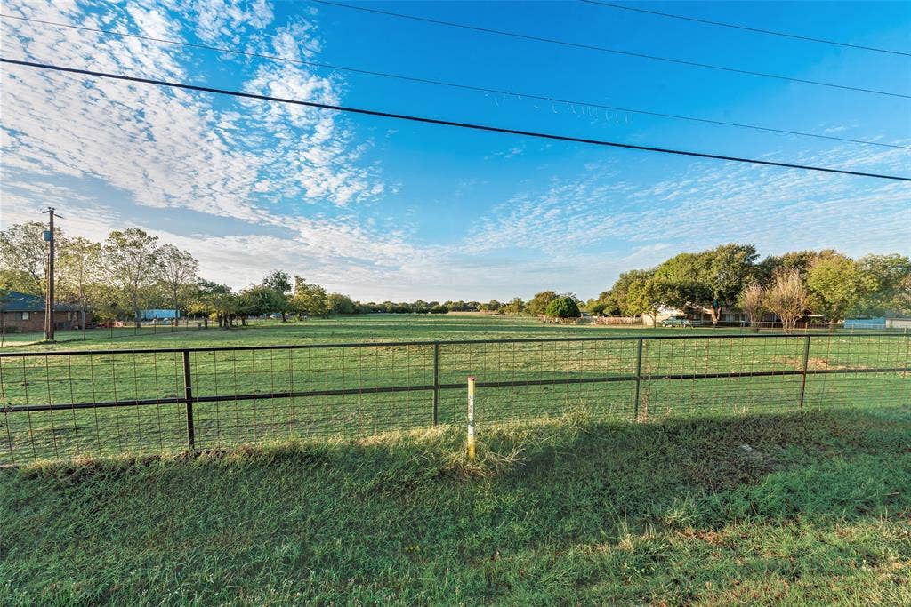 0 Johnson Lane, Ovilla, TX 75154 Expansive open pasture featuring a metal grid fence and mature tree clusters