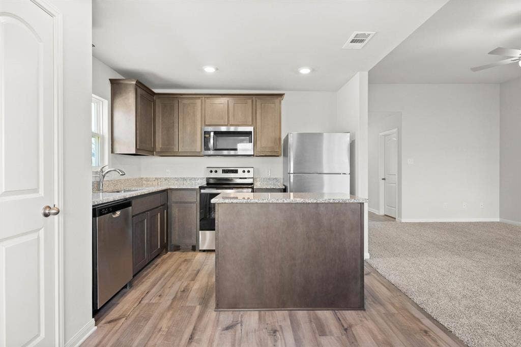 6308 Hyena Hollow Drive, Dallas, TX 75241 Kitchen with a center island, sink, light hardwood / wood-style flooring, ceiling fan, and appliances with stainless steel finishes