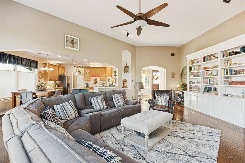 2404 Creek Ridge Drive, McKinney, TX 75072 Vaulted ceilings, built-in floor-to-ceiling cabinetry, arched architectural detailing, and wood-finish flooring