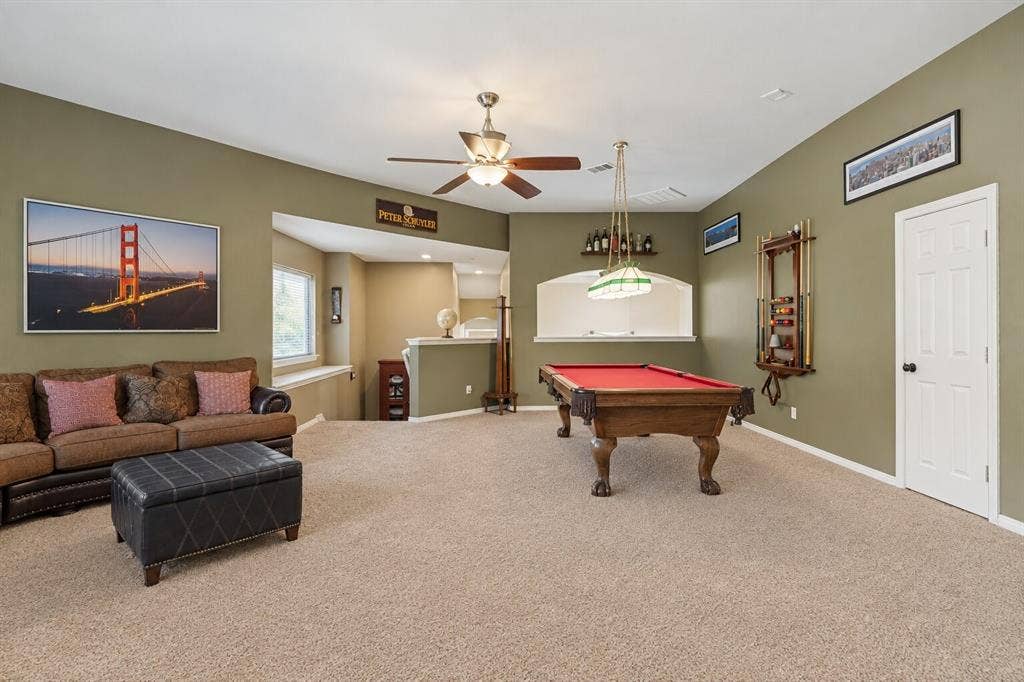 2404 Creek Ridge Drive, McKinney, TX 75072 Open-concept room featuring a vaulted ceiling, ceiling fan with integrated lighting, wall-recessed arched niche, and neutral wall-to-wall carpeting