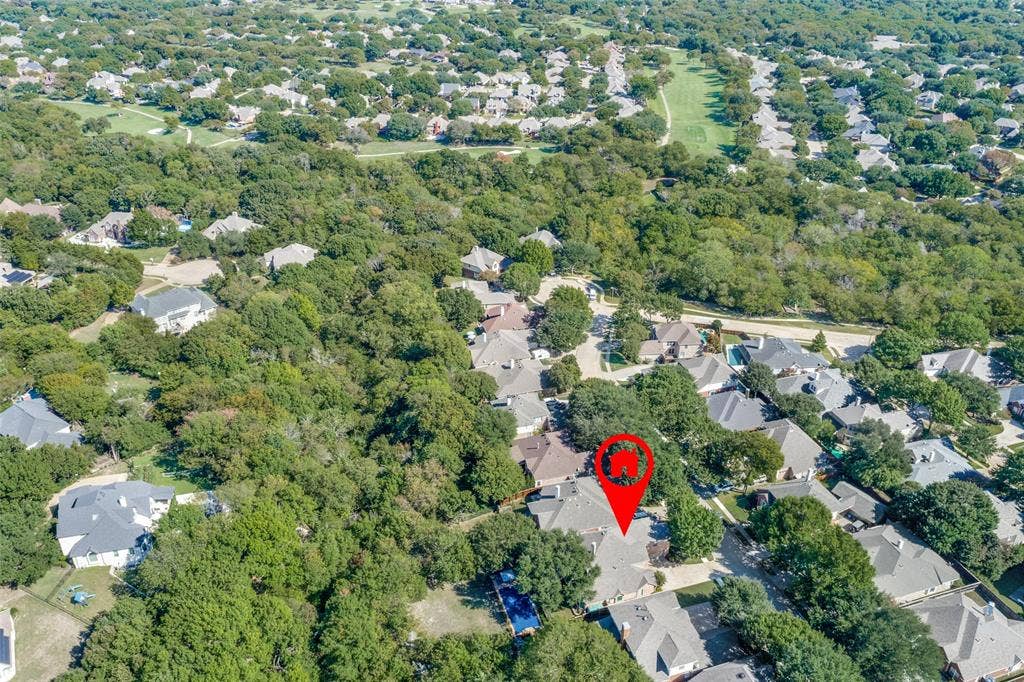 2404 Creek Ridge Drive, McKinney, TX 75072 Aerial perspective of a residential property featuring a backyard swimming pool, stone-surface roofing, and dense perimeter tree canopy