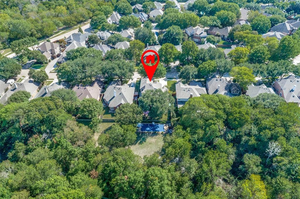 2404 Creek Ridge Drive, McKinney, TX 75072 Aerial perspective featuring a residential lot with a rectangular swimming pool, expansive wooded grounds, and mature tree canopy