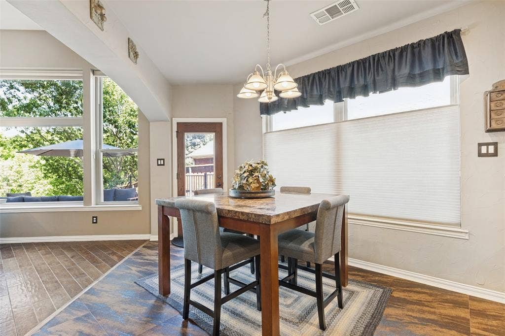 2404 Creek Ridge Drive, McKinney, TX 75072 Wood-finish flooring, multi-pane windows with cellular shades, and a polished metal multi-bulb chandelier