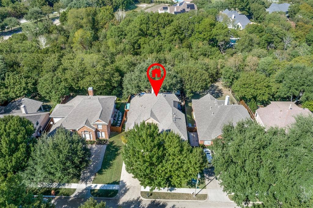 2404 Creek Ridge Drive, McKinney, TX 75072 Aerial perspective of residential property featuring a multi-gabled roofline and dense perimeter of mature trees
