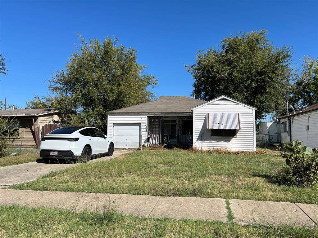 548 N 4th Street, Garland, TX 75040 Single-story exterior featuring horizontal siding, a gabled roofline, an attached one-car garage, and a metal window awning