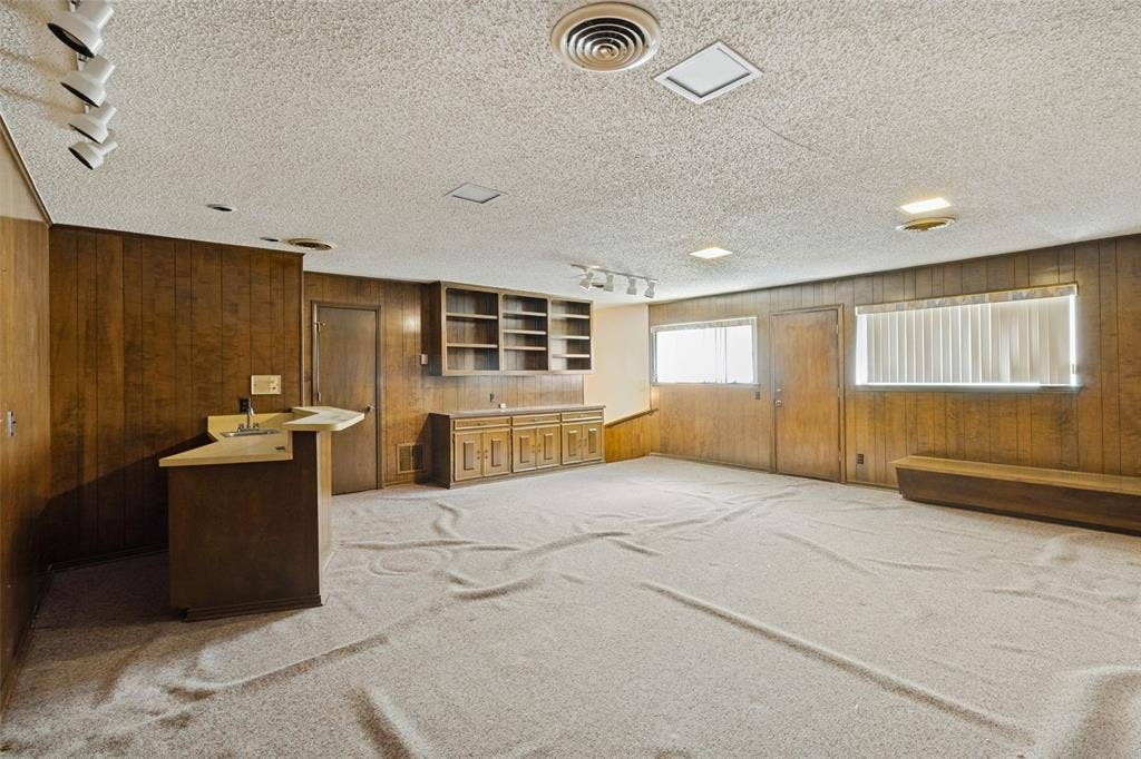 6936 Wildglen Drive, Dallas, TX 75230 Upstairs game room with built-in bar, extensive wood paneling, built-ins and half bath