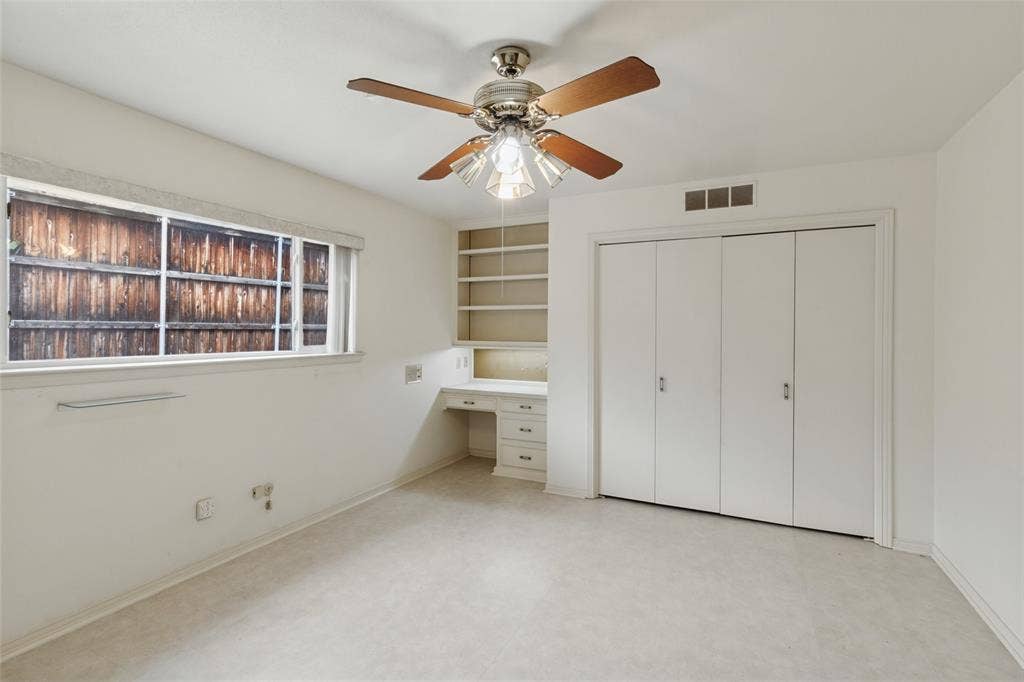 6936 Wildglen Drive, Dallas, TX 75230 Split bedroom with a built-in desk with overhead shelving, ceiling fan and a double-door closet