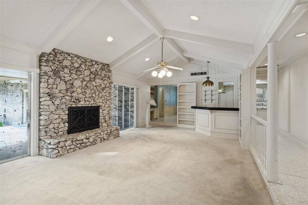 6936 Wildglen Drive, Dallas, TX 75230 Vaulted ceilings with exposed beams, floor-to-ceiling stone fireplace, built-in wet bar, and recessed lighting