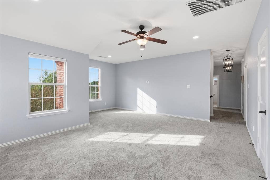 Neutral-toned interior featuring wall-to-wall carpeting, recessed lighting, a multi-blade ceiling fan with integrated lighting, and multipane windows