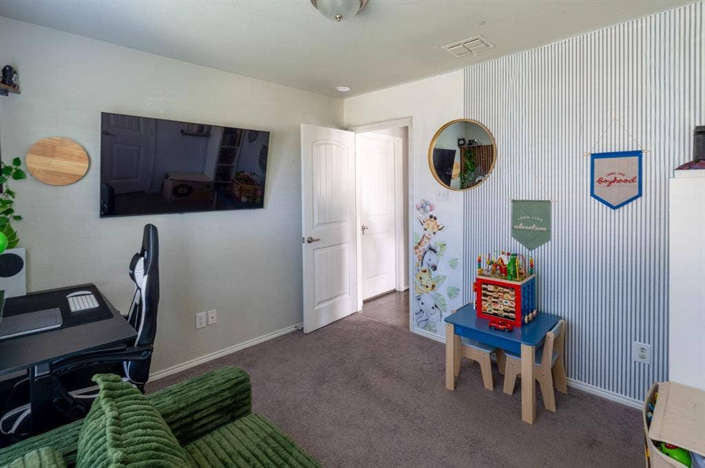 Interior room featuring vertical pinstripe wallpaper, wall-to-wall carpeting, and a flush-mount ceiling light fixture