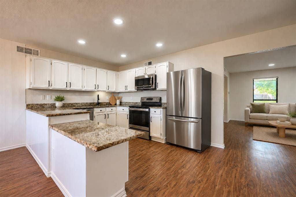 Kitchen featuring white cabinetry, stone-surface countertops, wood-finish flooring, recessed lighting, and stainless steel appliances