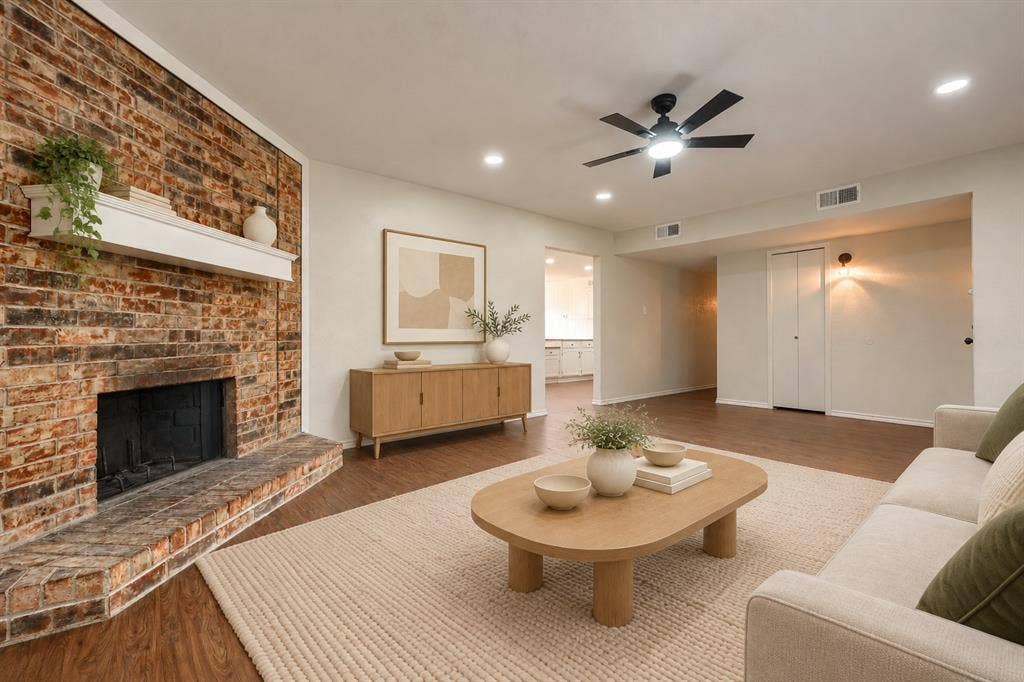 Floor-to-ceiling exposed brick fireplace with a white mantel, recessed lighting, wood-finish flooring, and a ceiling fan