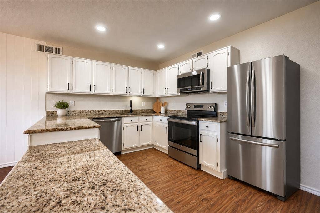 Kitchen featuring white cabinetry, stone-finish countertops, stainless steel appliances, recessed lighting, and wood-finish flooring