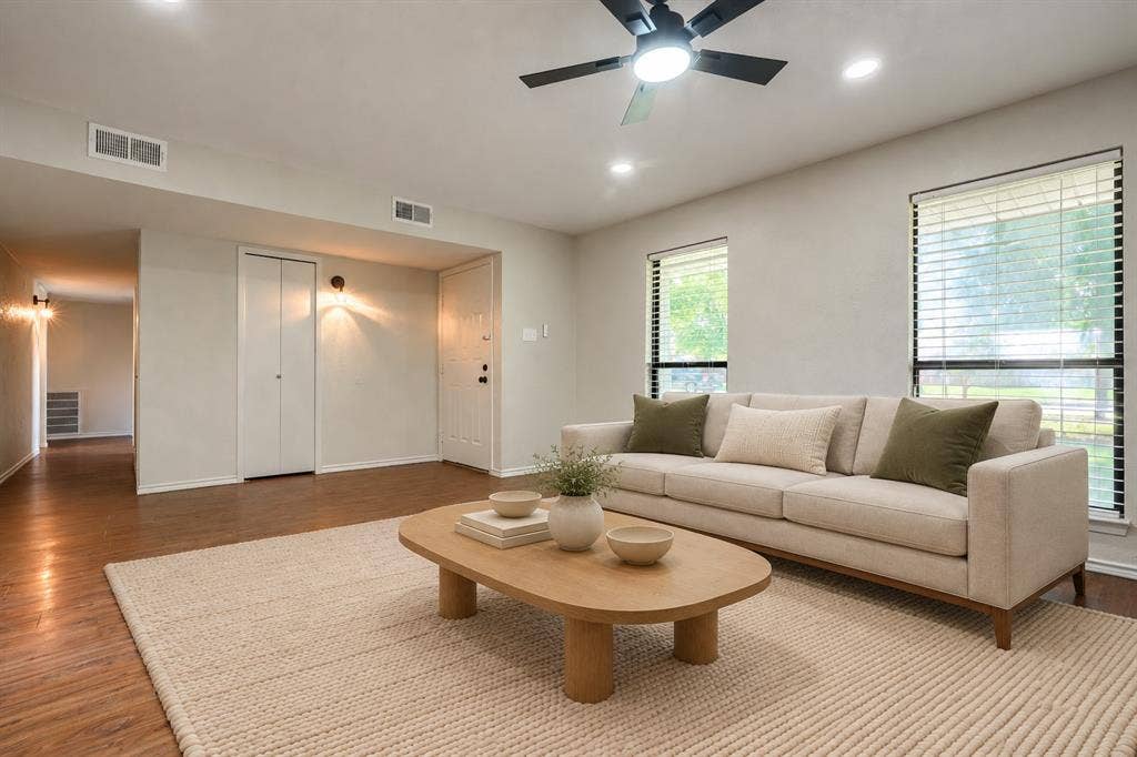 Wood-finish flooring, recessed lighting, ceiling fan with integrated light, and large windows with horizontal blinds