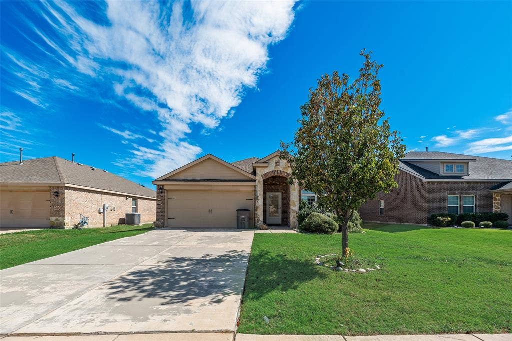 Single-story residence featuring a front-facing attached garage, stone and siding exterior, arched covered entryway, and a concrete driveway