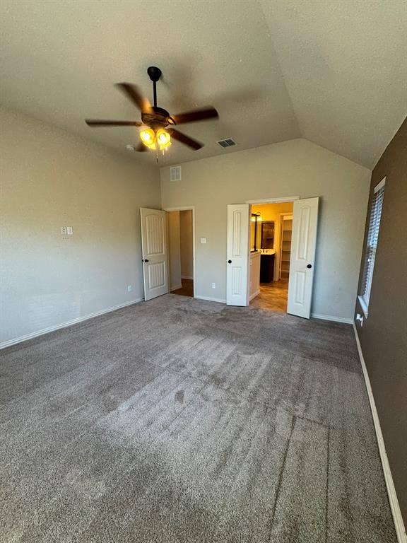 3953 Hollow Lake Road, Fort Worth, TX 76262 Vaulted ceilings featuring a central ceiling fan with integrated lighting, neutral wall tones, carpeted flooring, and double doors opening to an auxiliary space