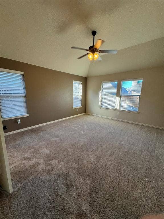 3953 Hollow Lake Road, Fort Worth, TX 76262 Vaulted ceiling featuring a central multi-blade ceiling fan with integrated lighting, neutral wall tones, and carpeting