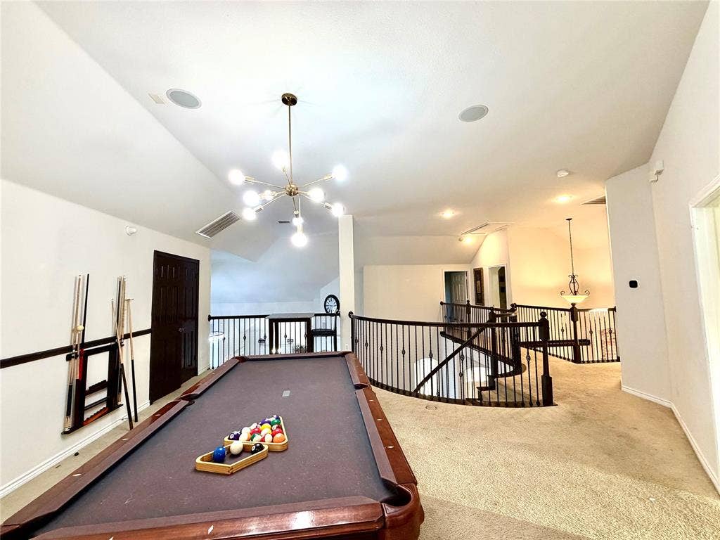 4514 Sea Sparrow Lane, Garland, TX 75043 Vaulted ceilings featuring a multi-arm sputnik chandelier, metal baluster railings, and recessed lighting