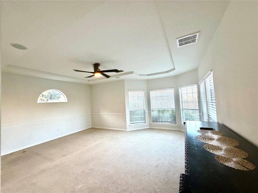 4514 Sea Sparrow Lane, Garland, TX 75043 Tray ceiling with integrated recessed lighting, expansive bay windows, arched accent window, and ceiling fan