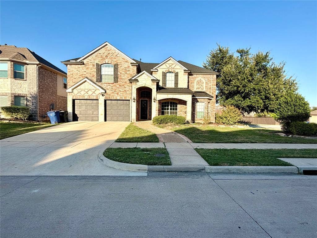 4514 Sea Sparrow Lane, Garland, TX 75043 Brick exterior with decorative stone accents, arched entryway, multi-gabled roofline, and an attached two-car garage