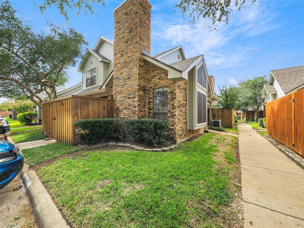449 Harris Street, #102L, Coppell, TX 75019 Multi-gabled exterior featuring a prominent full-height brick chimney, horizontal siding, and a concrete walkway