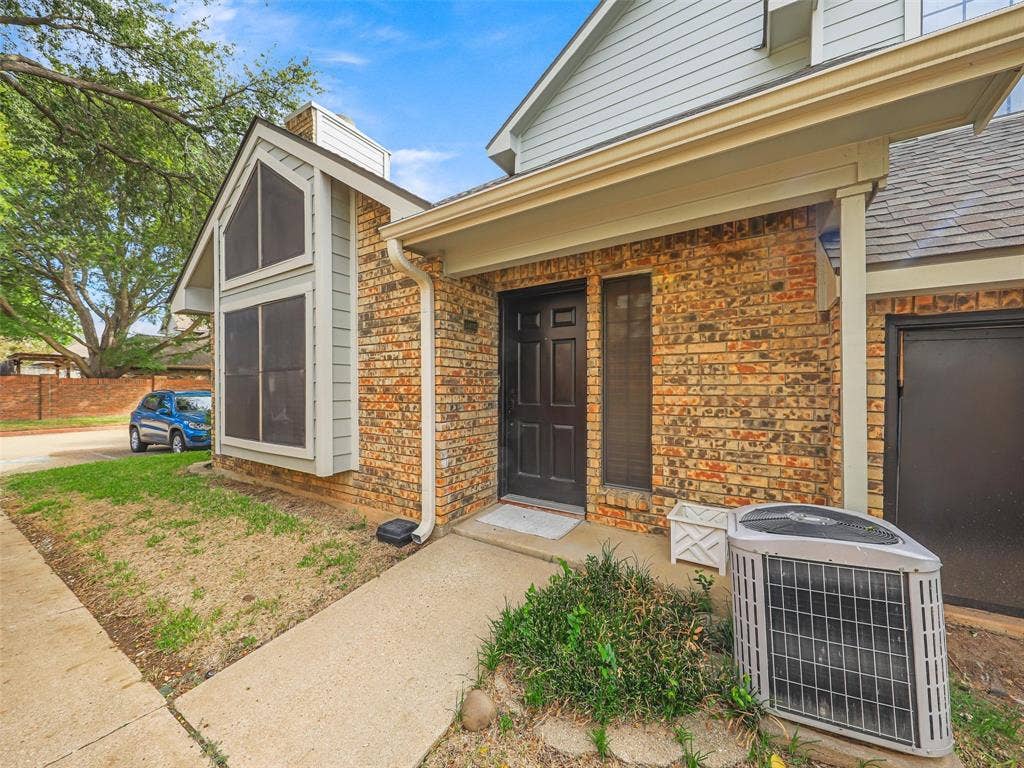 449 Harris Street, #102L, Coppell, TX 75019 Multi-textured exterior featuring a brick facade, siding accents, a prominent gable roofline, and a panelled front door