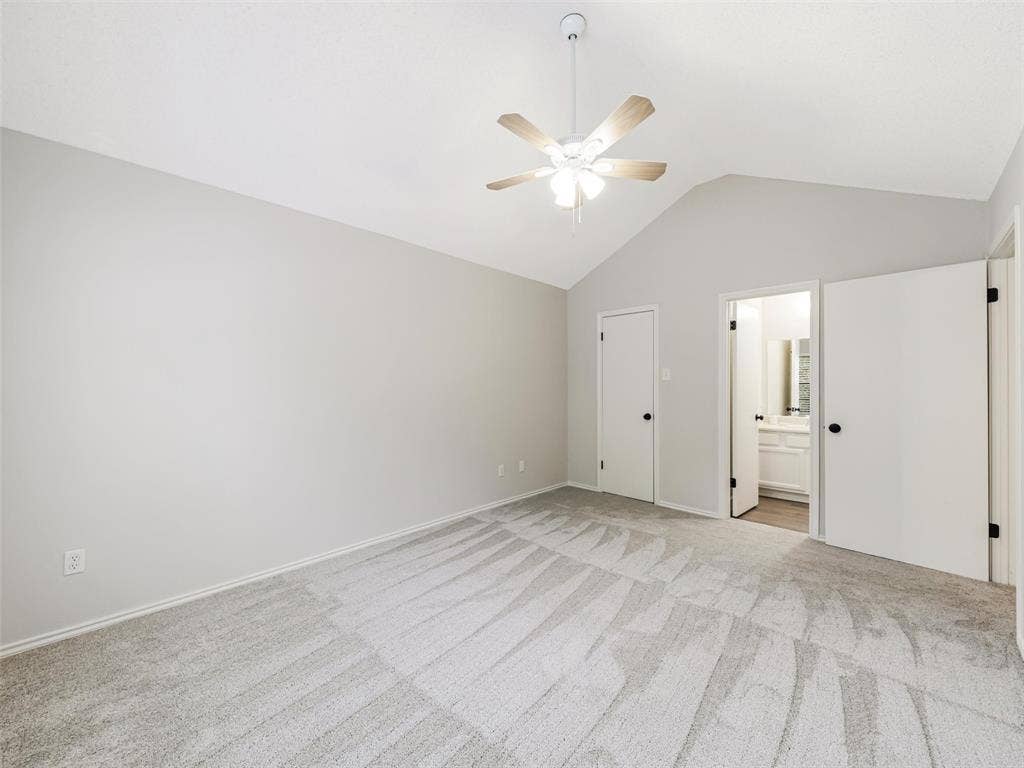 449 Harris Street, #102L, Coppell, TX 75019 Vaulted ceiling featuring a central lighted ceiling fan, neutral wall tones, and neutral-toned carpeting