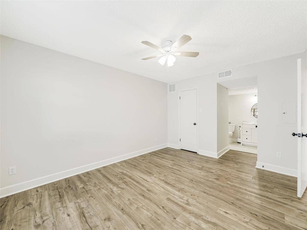 449 Harris Street, #102L, Coppell, TX 75019 Neutral wall tones, wood-finish flooring, and a ceiling-mounted light fixture with fan