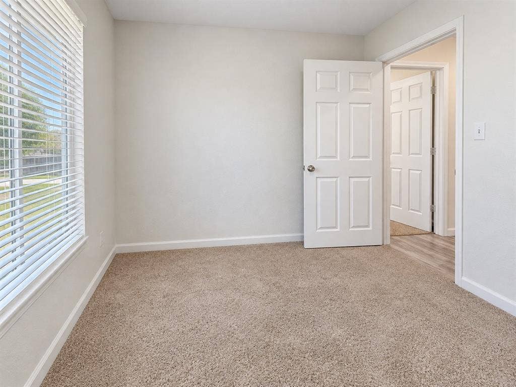Neutral-toned carpeting, white six-panel interior doors, and horizontal slat window blinds
