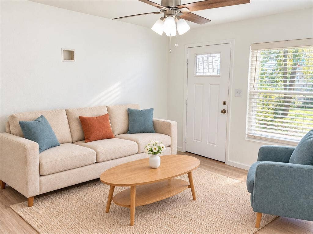 Wood-finish flooring, white paneled door with glass inlay, wood-blade ceiling fan with integrated lighting, and horizontal window blinds