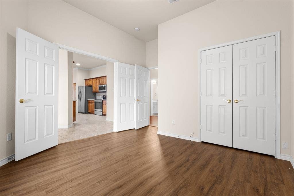 Interior room featuring wood-finish flooring, double-panel interior doors, and high ceilings