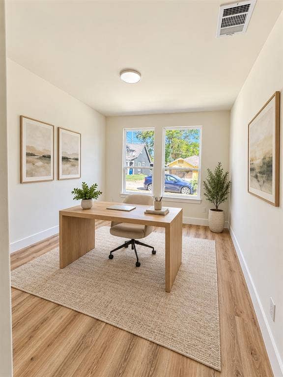 Neutral-toned interior featuring wood-finish flooring, dual windows, and a circular flush-mount ceiling light fixture
