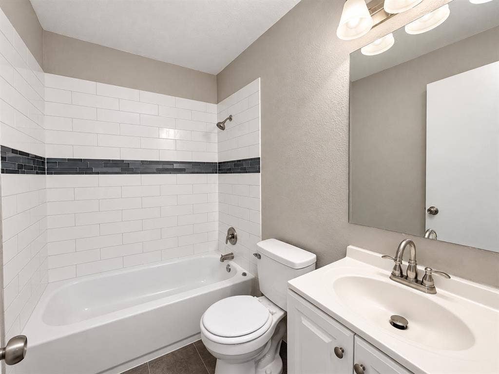 5140 Dimple Jackson Street, Dallas, TX 75210 Full bathroom featuring a tiled tub and shower combination with modern finishes.