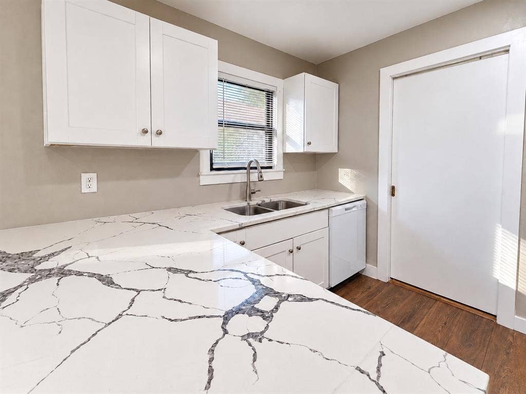 5140 Dimple Jackson Street, Dallas, TX 75210 Updated kitchen featuring white cabinetry, quartz countertops, and a double-basin sink.