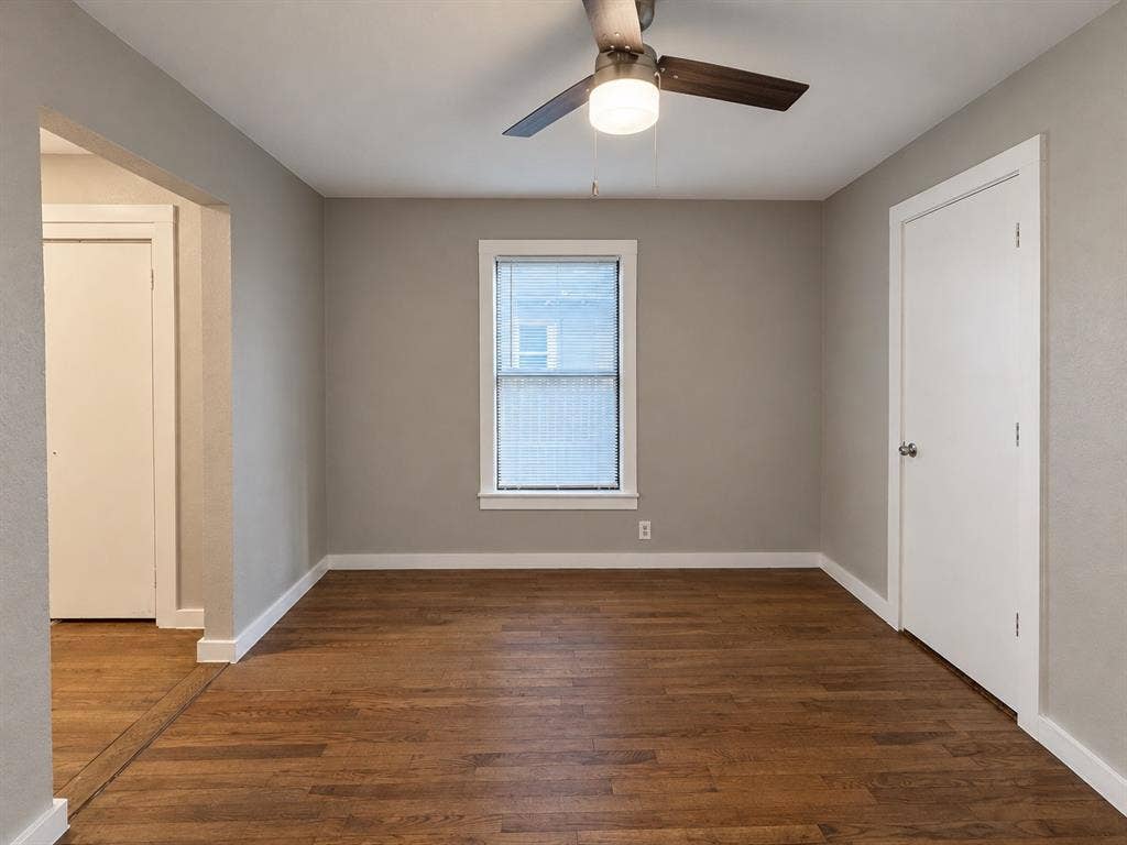 5140 Dimple Jackson Street, Dallas, TX 75210 Bedroom featuring wood flooring, neutral wall colors, and a ceiling fan.
