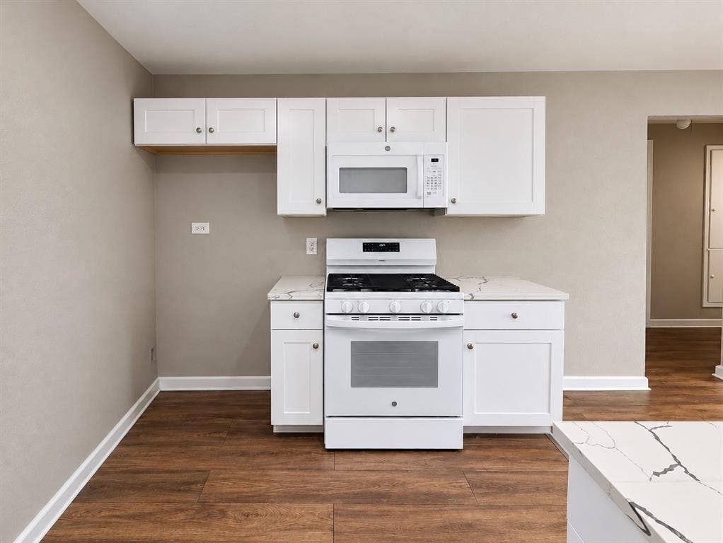 5140 Dimple Jackson Street, Dallas, TX 75210 Additional kitchen view highlighting white cabinetry, gas range, and microwave.