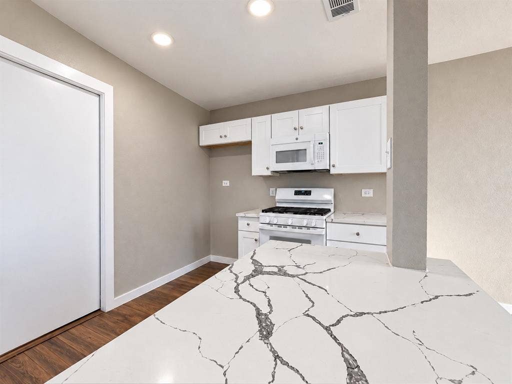 5140 Dimple Jackson Street, Dallas, TX 75210 Beautiful quartz countertops with distinctive veining and convenient breakfast bar.