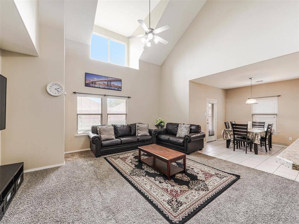 9720 Tipperary Drive, McKinney, TX 75072 Vaulted ceilings, expansive windows, overhead lighting fixture, tiled flooring, and carpeted flooring