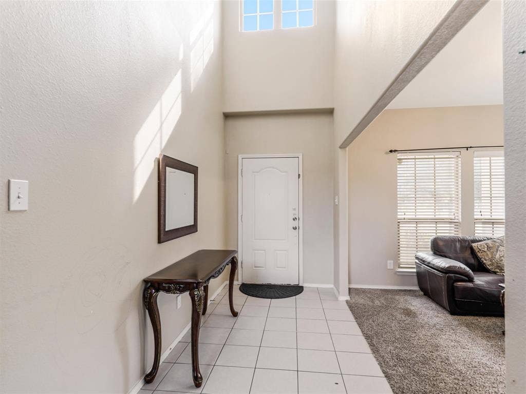 9720 Tipperary Drive, McKinney, TX 75072 Entryway featuring high ceilings, transom windows, and light-toned tile flooring