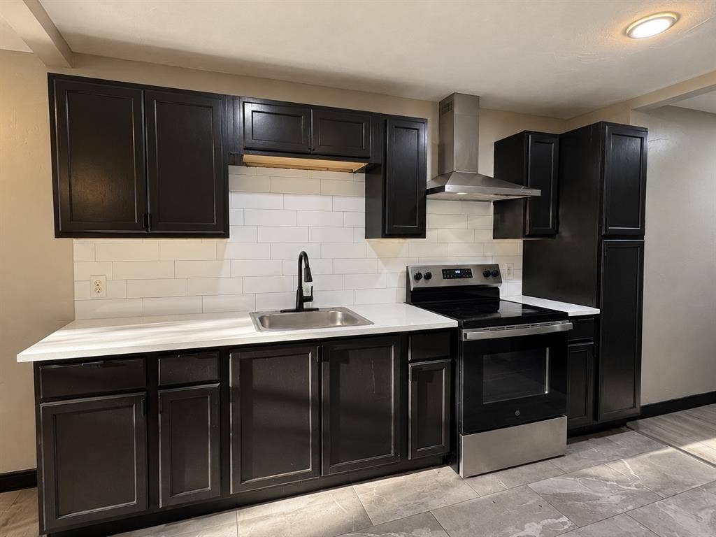 1817 N Alexander Street, Sherman, TX 75092 kitchen featuring dark cabinetry, light countertops, and a classic subway tile backsplash.