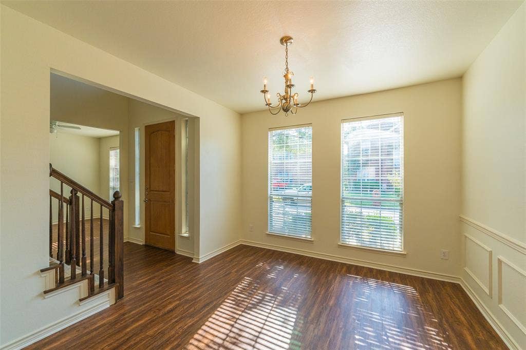 Wood-finish flooring, wainscoting, multi-pane windows, and a traditional chandelier